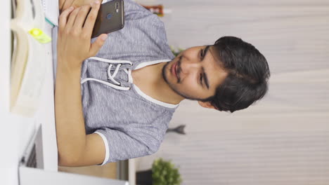 Vertical-video-of-Male-student-chatting-with-his-girlfriend-on-the-phone.